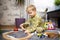 Baby playing with toy railroad, trains and cars on the floor