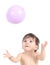 Baby playing and trying to catch a balloon