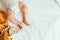 Baby playing with a wooden toy on white linens