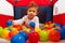 Baby in playpen with balls