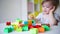 Baby plays in the constructor. small child builds a castle out of blocks. concept of development of fine motor skills