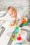 Baby plays on floor with educational toys, rattles and teething toys. Crawling babies at 8 months