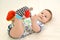 The baby plays legs in color socks with rattles