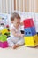 Baby plays nesting blocks at home