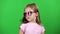 Baby posing for video cameras with glasses. Green screen. Slow motion