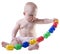 Baby pulling up large plastic beads.