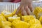 Baby reaching hand to to shiny yellow sweet corn