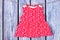Baby red dress hanging on clothesline.