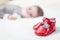 Baby red shoes and babe lying on the background