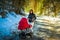 Baby in red stroller in forest countryside with mother. Relax in nature in Winter sunny day