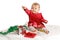 Baby in red velvet Christmas dress reaches up