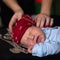 Baby in a rocker bandana lies with a guitar and a microphone