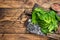 Baby romain green salad leaves on wooden cutting board. wooden background. Top view. Copy space