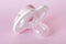Baby`s dummy isolated on pink closeup