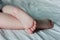 The baby`s feet. The toddler is sleeping on the bed. Closeup