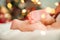 Baby`s first Christmas. Feet of newborn close-up on background of New Year`s lights and Christmas tree