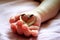 Baby`s hand holding a heart