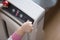 The baby`s hand pressing the power button on the air purifier to clean up the polluted air