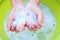 Baby`s hands hold soap suds on the background of the Cup, close-up, top view-the concept of washing hands before eating