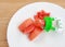 Baby`s nibbler and fresh ripe papaya fruit on white plate against wood background, Organic baby food concept