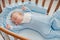 Baby`s restful sleep. Newborn baby in a wooden crib. The baby sleeps in the bedside cradle.