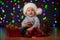 Baby in Santa Claus hat on festive background