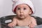 Baby with Santa Hat sitting in Wash Basin