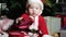 Baby in Santa suit, Santa Claus little boy, child sits in the carnival costumes, Christmas costumes under the Christmas