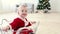 Baby santa suit sit in basket with Christmas tree