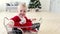 Baby santa suit sit in basket with Christmas tree