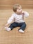 Baby seated on a bamboo floormat