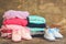 Baby shoes, pink and blue clothing on the old wooden background.