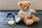 Baby shoes and teddy bear on blue wooden floor background