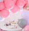 Baby shower party for girl. Treats on table in room decorated with balloons