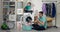 Baby sits on the washing machine while dad puts the laundry in. The boys spend time together while doing household