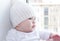 Baby sits at a window overlooking the next house