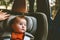 Baby sitting in safety rear-facing car seat looking at window