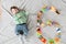 Baby six months top view. Happy baby in a hat and a diaper lying on the background of the carpet, smiling baby Toddler in a shirt