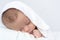 Baby sleep under a white blanke