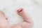 Baby Sleeping with Hands Curled Against White Blanket