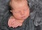 Baby sleeping, pressing hands to himself, closeup