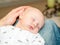 A baby sleeps comfortably on his father\'s lap