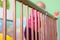 Baby standing in a crib and holding side of the bed.