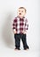 Baby Stands in Flannel and Jeans Looking Left