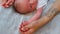 Baby stretching concept. Closeup indoor shot of two adult tattooed hands of a parent holding their infant baby's