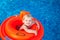Baby swimming in the orange float
