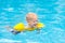 Baby in swimming pool. Kids swim