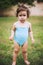 Baby in swimming suit standing in grass