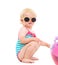 Baby in swimsuit and sunglasses playing with ball