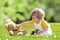 Baby with teddy bear on a summer meadow